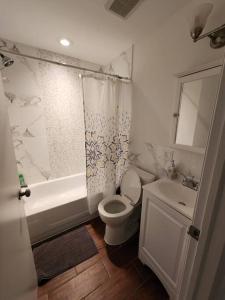 a bathroom with a toilet and a tub and a sink at Deluxe Studio minutes from NYC! in Union City