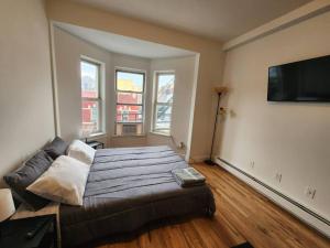 a bedroom with a large bed and a couch at Deluxe Studio minutes from NYC! in Union City
