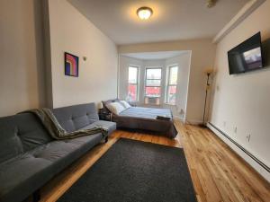 a living room with a couch and a bed at Deluxe Studio minutes from NYC! in Union City