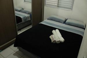 2 toallas plegadas en una cama en una habitación en Casa 02 Quartos Condomínio Aceita Pet en Ourinhos