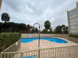 een zwembad met een hek eromheen bij Departamento 4 esquinas a pasos de avenida Del Mar La Serena in La Serena