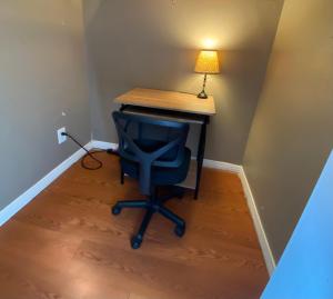 a desk with a blue chair and a lamp at Pelican Nest-Heated Pool Jacuzzi Tub Pvt Balcony in Pensacola