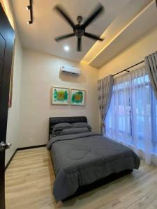 een slaapkamer met een bed en een plafondventilator bij Murni Inn Kampung Perigi in Yan