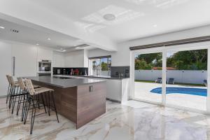 een keuken met een groot eiland met barkrukken bij Villa Bianco in Miami