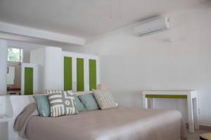 a bedroom with a bed with green and white walls at Casa Faro in Troncones