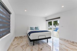 een slaapkamer met een bed in een witte kamer bij Villa Bianco in Miami