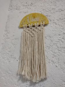 a yellow beaded item hanging on a wall at Monoambiente in Mercedes
