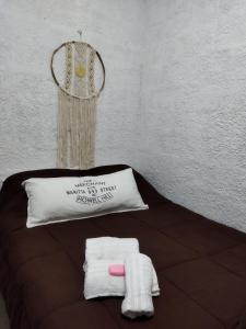 a bed with a pillow and towels on it at Monoambiente in Mercedes