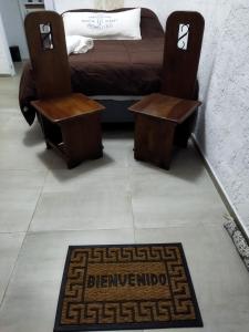 a bedroom with a bed and two chairs and a rug at Monoambiente in Mercedes