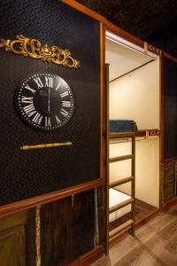 a clock on the wall of a room with a ladder at The Clock Hostel & Suites in Cartagena de Indias