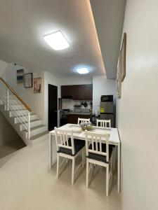 a kitchen with a white table and chairs and a staircase at FLY & REST GUESTHOUSE - Mactan-Cebu International Airport in Lapu Lapu City