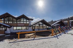 un lodge de esquí con un montón de esquís en la nieve en Mountain Lodge at Okemo, en Ludlow