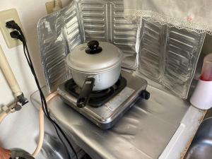 a slow cooker sitting on top of a stove at 民泊くるり in Nagoya