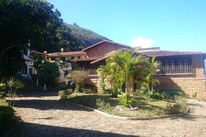 a house with palm trees in front of it at Apto perto de Itaipava in Petrópolis