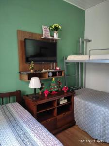 a bedroom with two twin beds and a television at Apto perto de Itaipava in Petrópolis