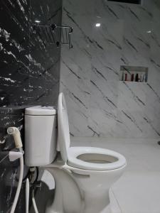 MedidirにあるVilla American Styleの大理石の壁のバスルーム(白いトイレ付)