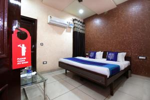 a bedroom with a bed with a sign on the wall at OYO 9808 Hotel Prem Sagar in Ludhiana