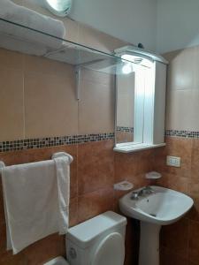 a bathroom with a sink and a toilet and a mirror at DEPARTAMENTO AVELLANEDA 3 5 3 4 2 3 6 2 6 3 con GARAJE PRIVADO perfecto para hacer noche y continuar viaje in Villa María
