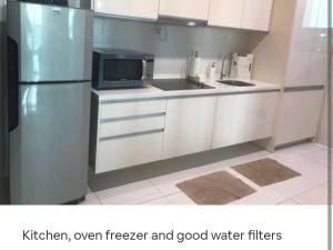 a kitchen with a refrigerator oven freezer and good water filters at Sky Loft Premium Bukit Indah in Johor Bahru