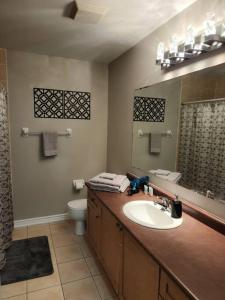 a bathroom with a sink and a toilet and a mirror at Beautiful home away from home in Milton