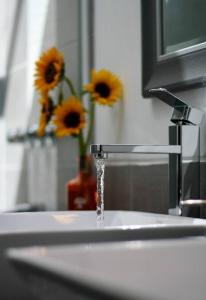 a sink with water running from a faucet with sunflowers at Casa de ensueño en el Valle Sagrado in Calca