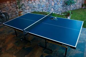 una mesa de ping pong azul con raqueta de tenis. en Casa de ensueño en el Valle Sagrado, en Calca