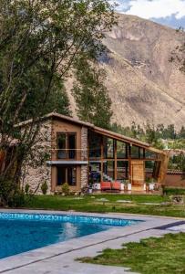 a house with a swimming pool in front of a mountain at Casa de ensueño en el Valle Sagrado in Calca