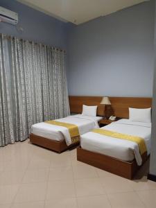 pokój hotelowy z 2 łóżkami i oknem w obiekcie Surya Palace Syariah w mieście Padang