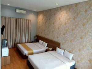 パダンにあるSurya Palace Syariahのベッド2台と窓が備わるホテルルームです。