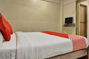 a bedroom with a bed with a red and white blanket at OYO Rana Residency Near Western Express Highway Metro Station in Mumbai