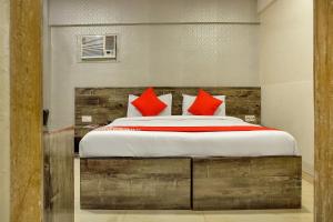 sypialnia z dużym łóżkiem z czerwonymi poduszkami w obiekcie OYO Rana Residency Near Western Express Highway Metro Station w Bombaju