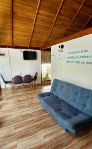 - un salon avec un canapé bleu et une table dans l'établissement Cabaña asteroide b 612, à Moñitos