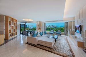 a living room with a white couch and a tv at Mission Hills Hotel Resorts Shenzhen in Bao'an