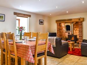 a dining room with a table and chairs and a fireplace at Llandremor Fawr Cottage in Llanedy