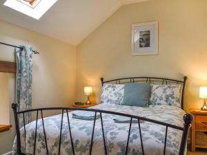 a bedroom with a bed and two lamps at Llandremor Fawr Cottage in Llanedy