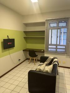 a living room with a couch and a television at Lindo Studio no Sudoeste, otima localizacao. in Brasilia