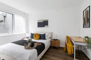 a bedroom with a bed and a desk and a window at Serene Coastal Haven in Melbourne