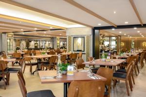 un restaurante con mesas de madera y sillas en una habitación en AnCasa Hotel Kuala Lumpur, Chinatown by AnCasa Hotels & Resorts en Kuala Lumpur