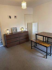 a living room with a table and a refrigerator at Big house with garden in Gillingham