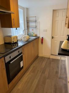 a kitchen with a sink and a stove top oven at Big house with garden in Gillingham