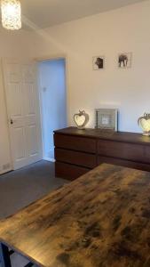 a room with a wooden table and a white door at Big house with garden in Gillingham