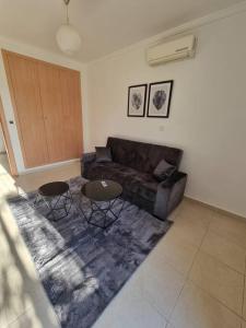 - un salon avec un canapé et deux tables dans l'établissement F5 -5 bedrooms Apt- Residence Hasnaoui avec parking Oran Algeria, à Oran