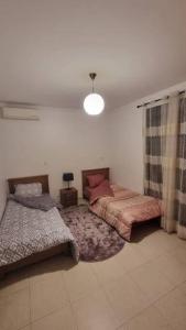 奧蘭的住宿－F5 -5 bedrooms Apt- Residence Hasnaoui avec parking Oran Algeria，一间卧室配有两张床和灯具