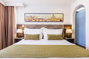 a bedroom with a large white bed and two lamps at Hotel Vilar América in Bogotá