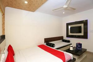 Schlafzimmer mit einem Bett und einem Flachbild-TV in der Unterkunft Super OYO Flagship 4957 Hotel China Town in Bhairaun Ghāt
