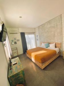 um quarto com uma cama e uma televisão em A7 Guesthouse em Canggu