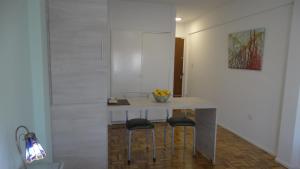 Adrogué的住宿－Monoambiente en pleno centro de Adrogué，厨房配有一张桌子和两张凳子