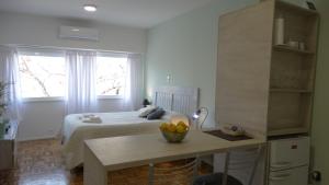 a bedroom with a bed and a table with a bowl of fruit at Monoambiente en pleno centro de Adrogué in Adrogué