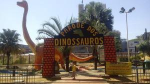 una señal para un parque de dinosaurios con un dinosaurio en él en Hostel Bimba Goiânia - Unidade 02, en Goiânia