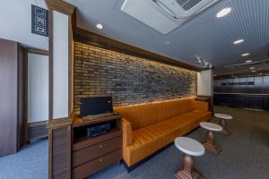 an office with a couch and a brick wall at Via Inn Shimonoseki in Shimonoseki +33 photos